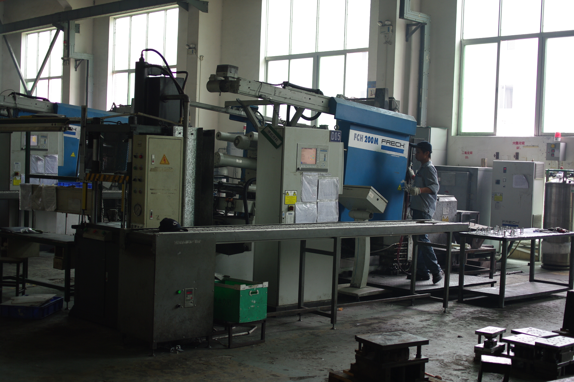 Die casting machine with roller conveyor on a factory floor